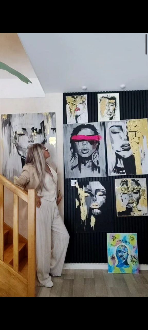 Tanya, artiste dans son atelier entourée de ses peintures